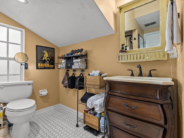 bathroom featuring toilet, tile patterned flooring, lofted ceiling, a textured ceiling, and vanity