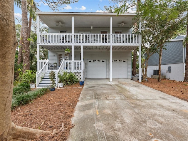 view of front of property featuring a garage, central air condition unit, a balcony, and covered porch