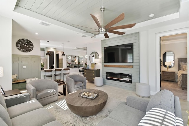 living room featuring ceiling fan, a large fireplace, wooden ceiling, and light hardwood / wood-style flooring