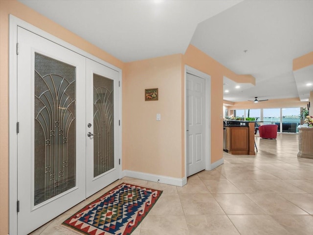 entryway with ceiling fan, french doors, and light tile patterned flooring