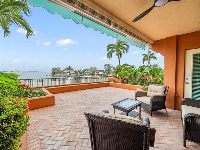 view of patio / terrace with ceiling fan and a water view