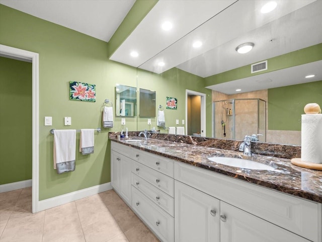 bathroom featuring tile patterned floors, an enclosed shower, and vanity