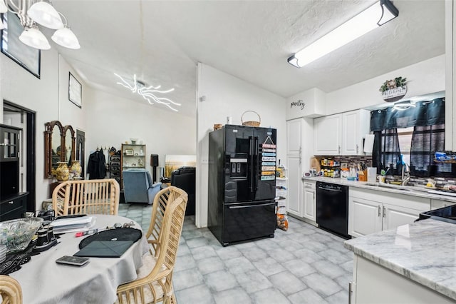 kitchen with black appliances, hanging light fixtures, a textured ceiling, white cabinets, and backsplash