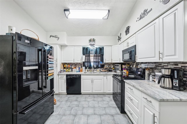 kitchen featuring white cabinetry, sink, and black appliances