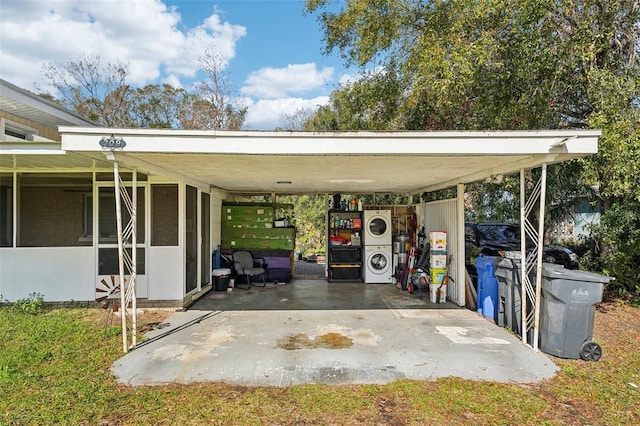 view of parking / parking lot featuring a carport and stacked washer / dryer