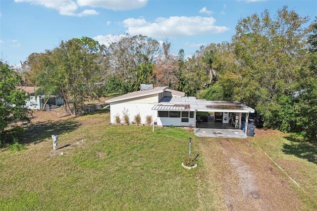 rear view of house featuring a lawn and a carport