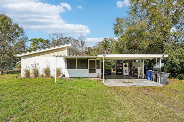 back of house featuring a carport, a sunroom, and a yard