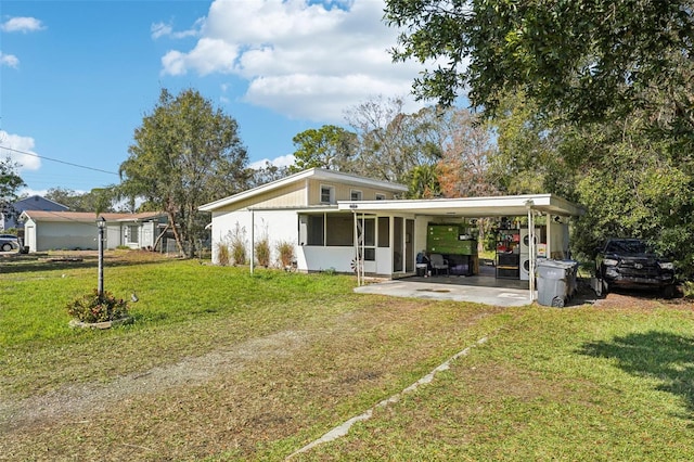 view of front of house with a front lawn, a carport, and a sunroom