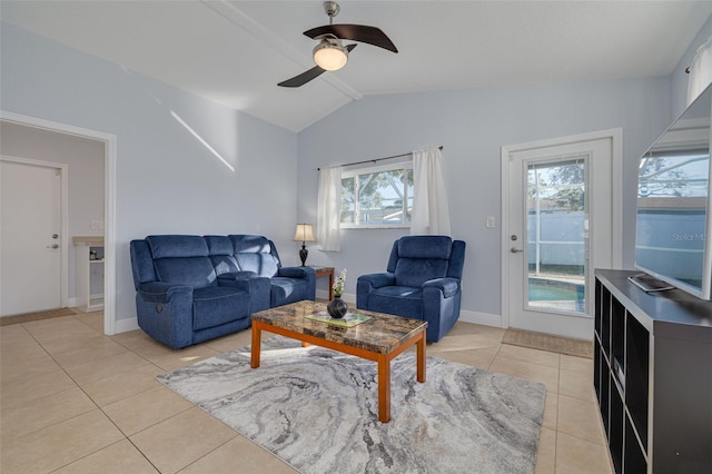 living room with a wealth of natural light, ceiling fan, light tile patterned floors, and vaulted ceiling