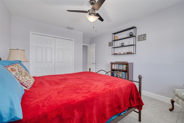 bedroom featuring ceiling fan, light tile patterned floors, a textured ceiling, and a closet