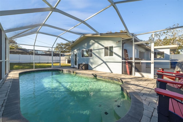 view of pool featuring glass enclosure and a patio area