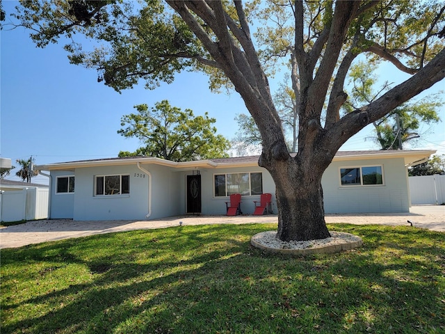 ranch-style home with a patio, a front lawn, and fence