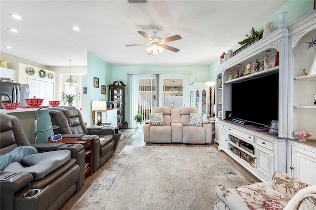 living room featuring ceiling fan and light hardwood / wood-style flooring