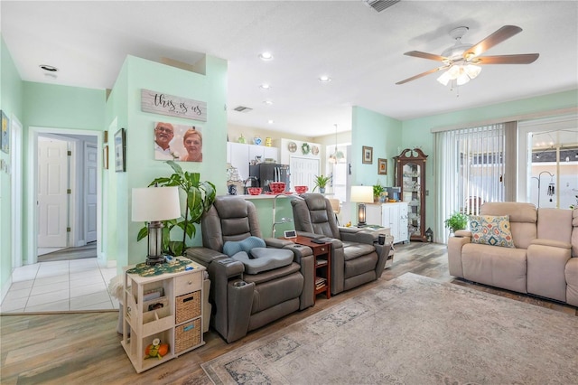 living room featuring ceiling fan and light hardwood / wood-style flooring