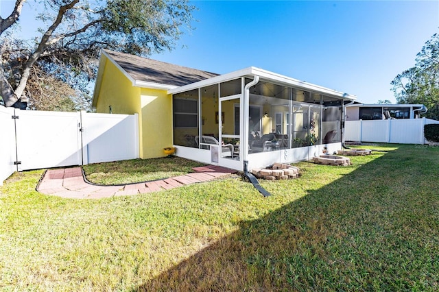 rear view of house with a sunroom and a yard