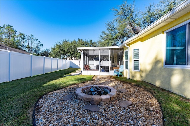 view of yard featuring an outdoor fire pit and a sunroom