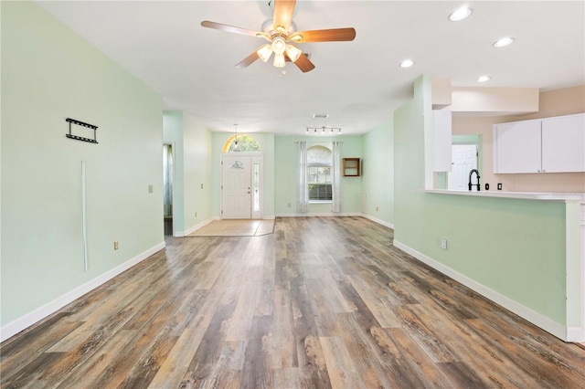 5215 New Brittany Ln, Zephyrhills, FL 33541 - unfurnished living room with recessed lighting, wood finished floors, a ceiling fan, baseboards, and a sink