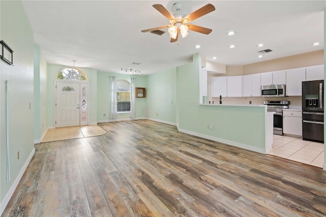 5215 New Brittany Ln, Zephyrhills, FL 33541 - kitchen with stainless steel appliances, light wood finished floors, white cabinetry, light countertops, and recessed lighting