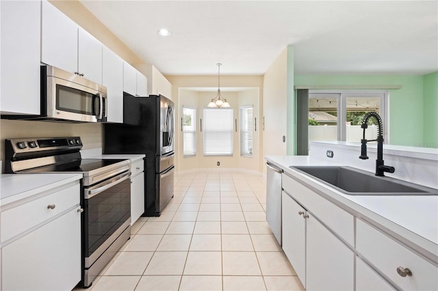 5215 New Brittany Ln, Zephyrhills, FL 33541 - kitchen featuring appliances with stainless steel finishes, a sink, a chandelier, light countertops, and white cabinetry