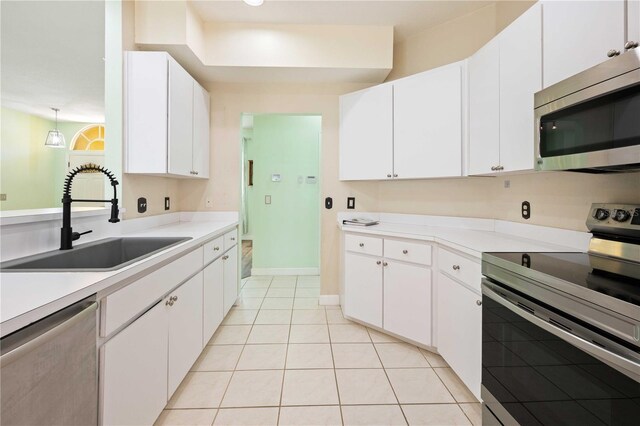 5215 New Brittany Ln, Zephyrhills, FL 33541 - kitchen with stainless steel appliances, a sink, light tile patterned floors, and white cabinets