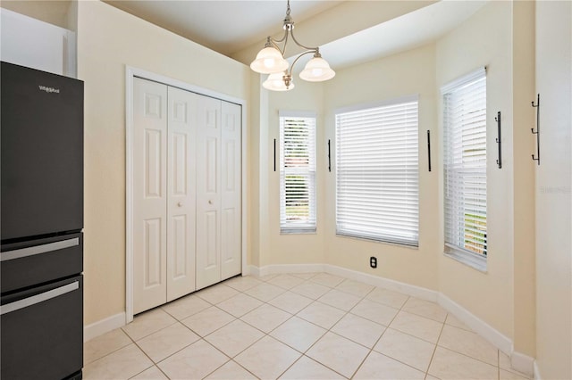 5215 New Brittany Ln, Zephyrhills, FL 33541 - unfurnished dining area featuring a chandelier, plenty of natural light, baseboards, and light tile patterned floors