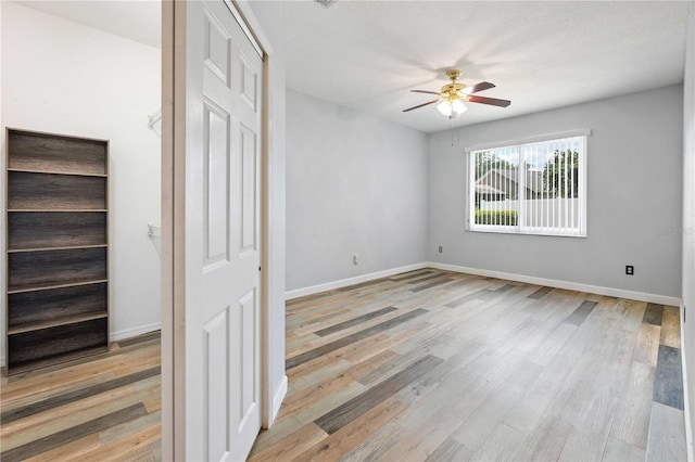 5215 New Brittany Ln, Zephyrhills, FL 33541 - unfurnished bedroom featuring wood finished floors, baseboards, and a ceiling fan