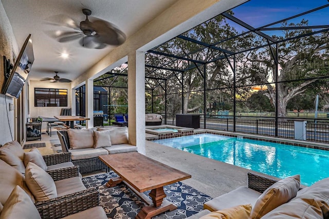 pool at dusk with glass enclosure, outdoor lounge area, ceiling fan, an in ground hot tub, and a patio