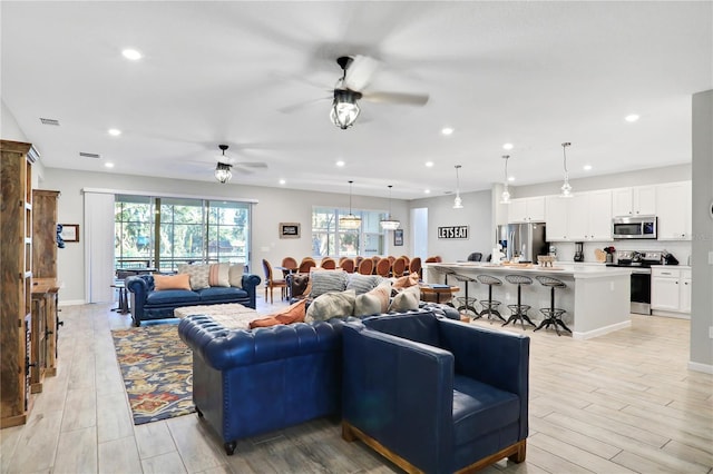 living room featuring ceiling fan and light wood-type flooring