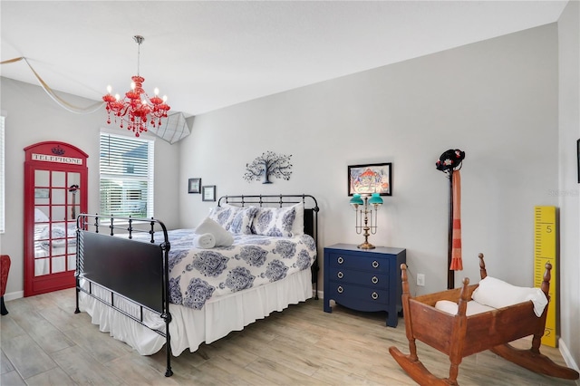 bedroom with light wood-type flooring and a notable chandelier