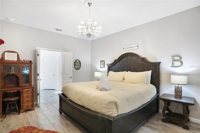 bedroom featuring a chandelier and light wood-type flooring