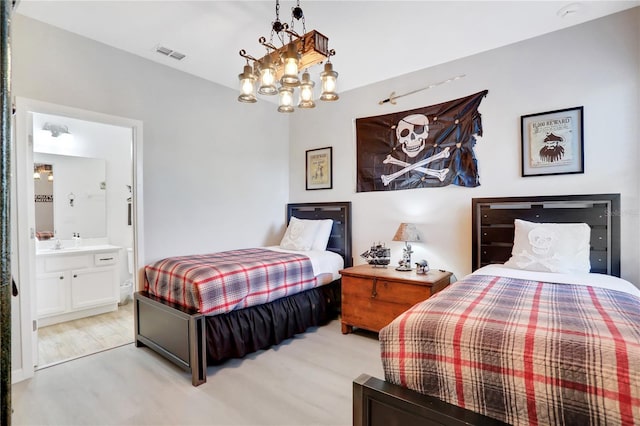 bedroom featuring a chandelier and ensuite bath