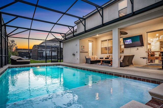 pool at dusk featuring an outdoor hangout area, a patio, and a lanai