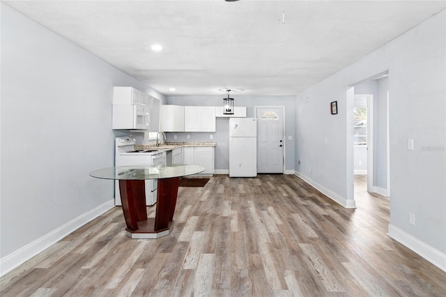 kitchen featuring sink, white cabinets, white appliances, and light wood-type flooring