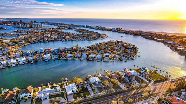 aerial view at dusk featuring a water view