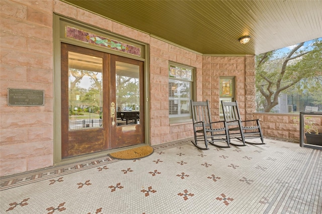 entrance to property with french doors and a porch