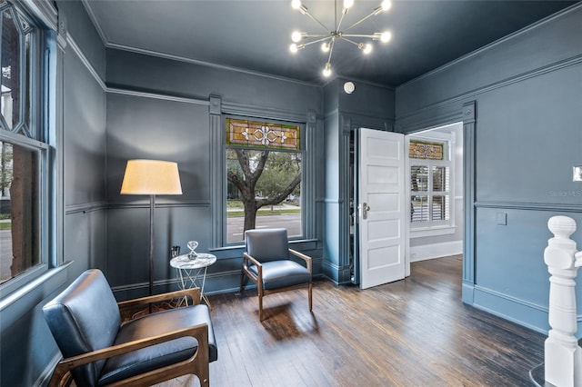 living area with a notable chandelier, dark hardwood / wood-style floors, and a wealth of natural light