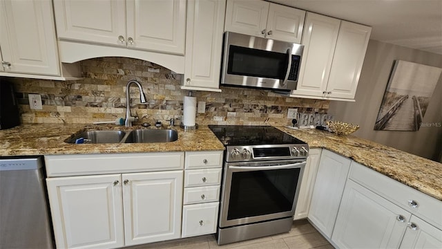 kitchen with white cabinetry, sink, backsplash, and appliances with stainless steel finishes