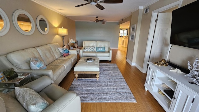 living room with crown molding, wood-type flooring, and ceiling fan