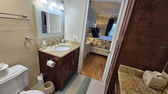 bathroom featuring vanity, crown molding, toilet, and hardwood / wood-style flooring