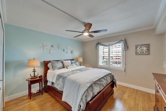 18325 Gulf Blvd Unit 407, Redington Shores, FL 33708 - bedroom with crown molding, light wood finished floors, baseboards, a ceiling fan, and a textured ceiling