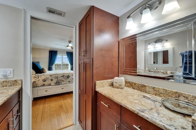 18325 Gulf Blvd Unit 407, Redington Shores, FL 33708 - bathroom featuring ensuite bath, vanity, a ceiling fan, and wood finished floors