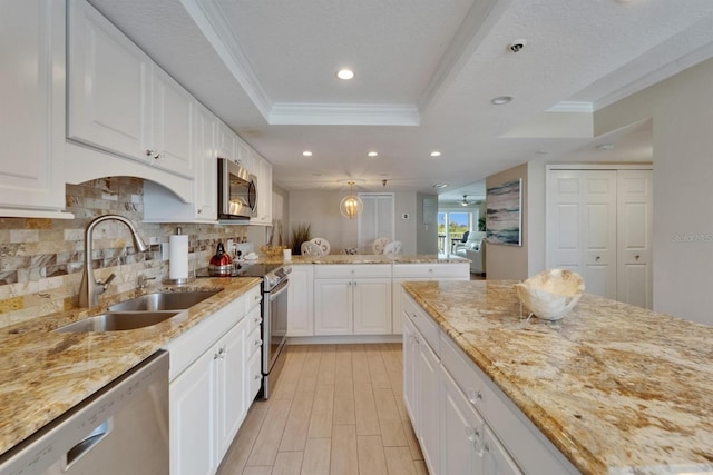 18325 Gulf Blvd Unit 407, Redington Shores, FL 33708 - kitchen featuring appliances with stainless steel finishes, a sink, a tray ceiling, a peninsula, and recessed lighting