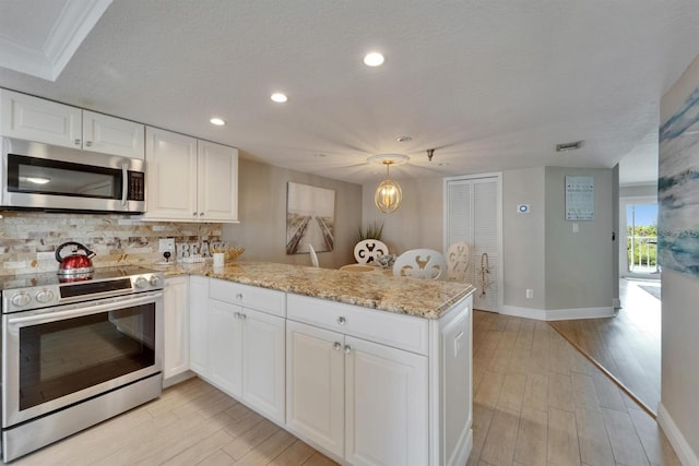 18325 Gulf Blvd Unit 407, Redington Shores, FL 33708 - kitchen with appliances with stainless steel finishes, a peninsula, recessed lighting, light wood-style floors, and decorative backsplash