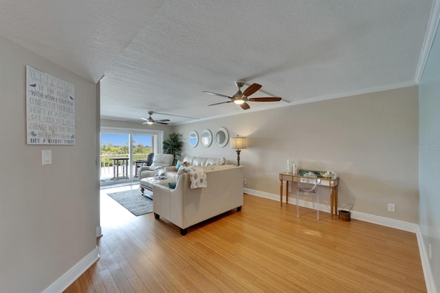 18325 Gulf Blvd Unit 407, Redington Shores, FL 33708 - living room featuring light wood-type flooring, baseboards, a textured ceiling, ceiling fan, and ornamental molding