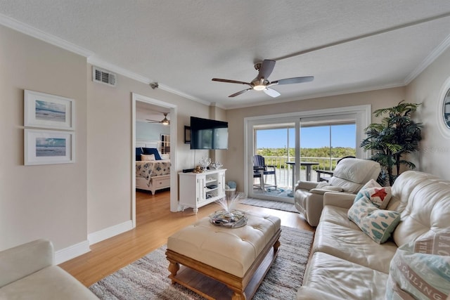 18325 Gulf Blvd Unit 407, Redington Shores, FL 33708 - living area with a ceiling fan, light wood finished floors, ornamental molding, a textured ceiling, and baseboards