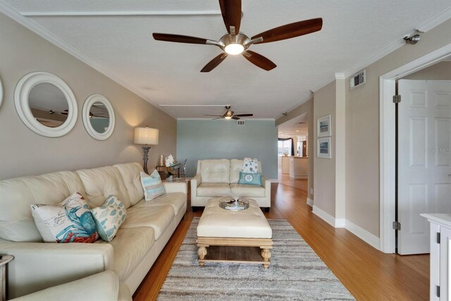 18325 Gulf Blvd Unit 407, Redington Shores, FL 33708 - living room featuring a ceiling fan, light wood-style floors, ornamental molding, and baseboards