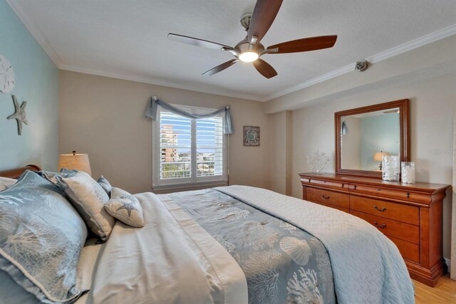 18325 Gulf Blvd Unit 407, Redington Shores, FL 33708 - bedroom with crown molding, light wood-style floors, and a ceiling fan