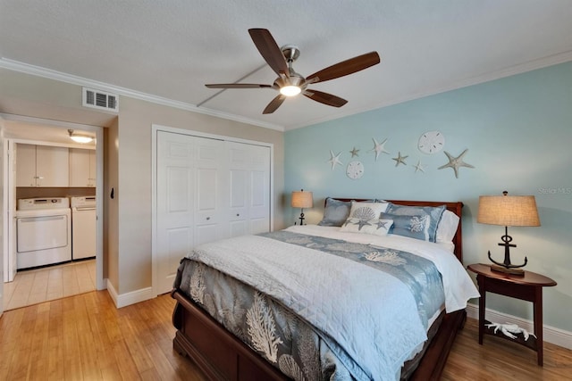 18325 Gulf Blvd Unit 407, Redington Shores, FL 33708 - bedroom featuring separate washer and dryer, crown molding, a closet, light wood finished floors, and baseboards