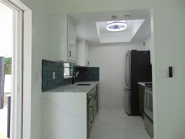 kitchen with backsplash, white cabinetry, a wealth of natural light, and sink