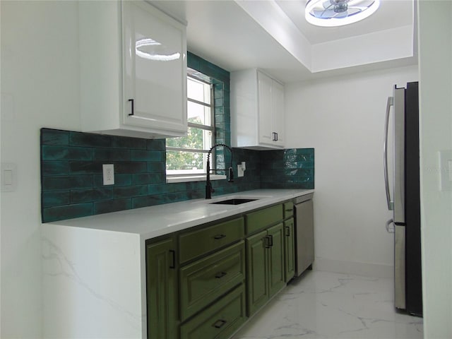 kitchen with sink, tasteful backsplash, appliances with stainless steel finishes, white cabinets, and green cabinetry